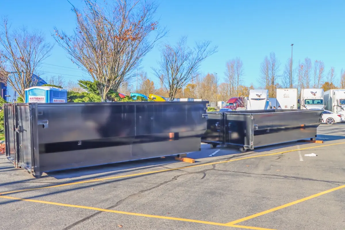 Professional dumpster rental service with roll-off container on residential driveway in Cohoes